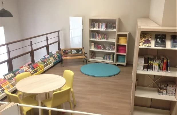 Intérieur de la médiathèque — espace de lecture et coin enfants