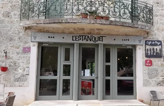 Entrée du Bar L'Estanquet avec enseigne et balcon en fer forgé