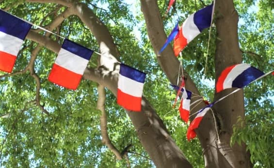 Drapeaux français suspendus dans les arbres pour la Fête nationale à Prayssas