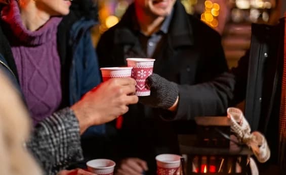 Visiteurs trinquant avec du vin chaud au marché de Noël de Prayssas